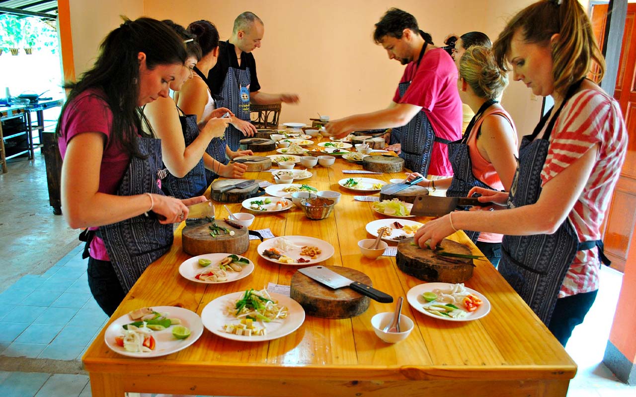 Group of travelers chopping ingredients during a Thai cooking class in Chiang Mai