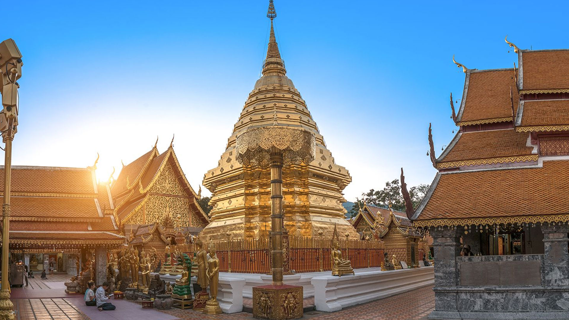 A golden temple on a hill with a panoramic view of Chiang Mai